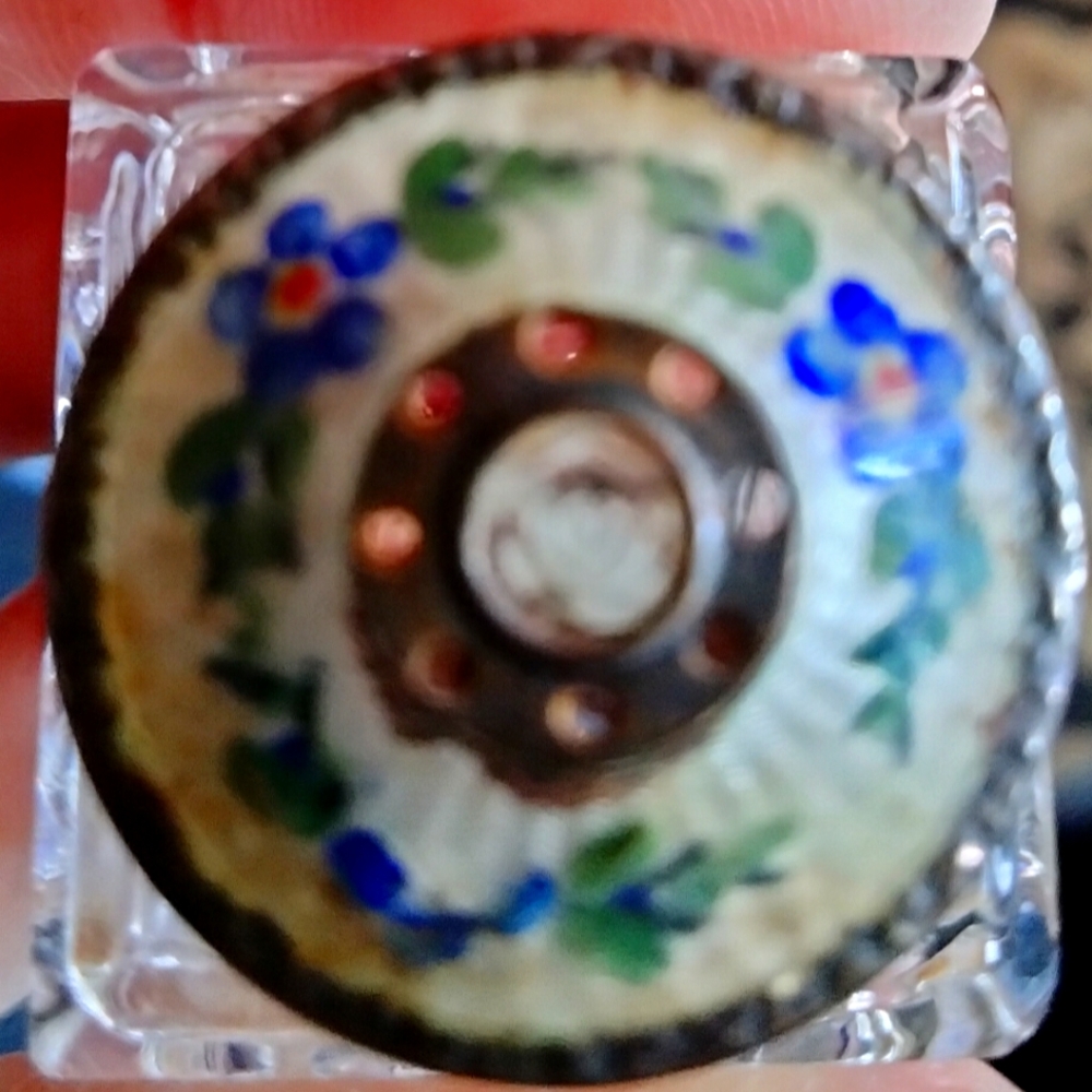 Antique salt shaker with floral decorated lid.